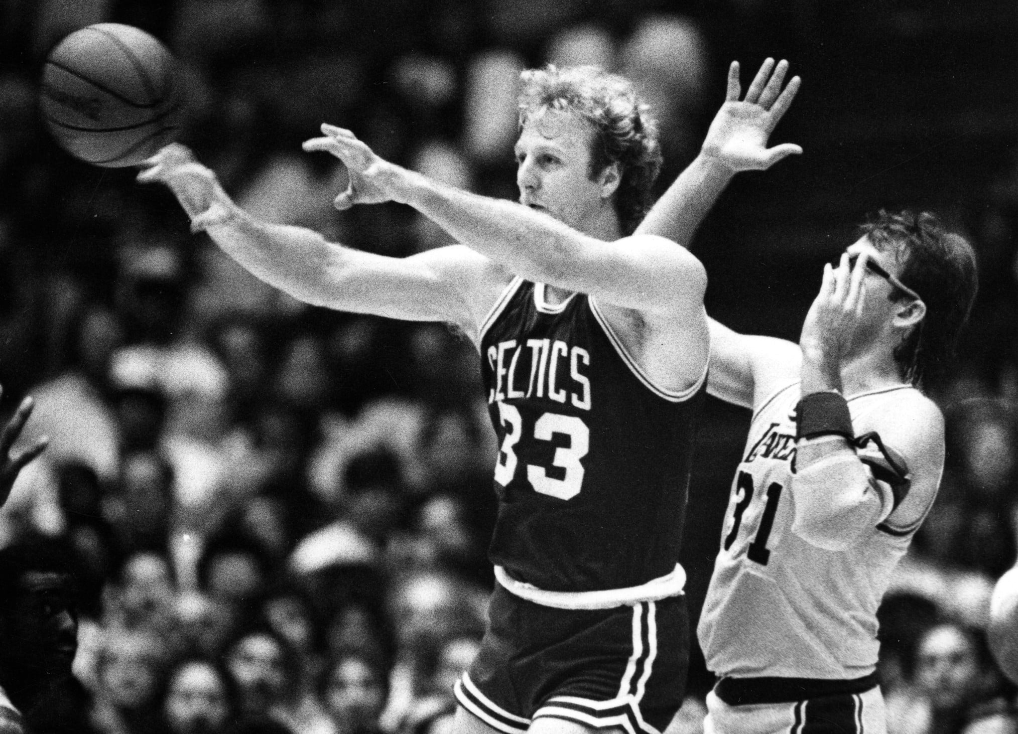 Boston Celtics forward Larry Bird starts a fast break in front of Los Angeles Lakers forward Kurt Rambis.