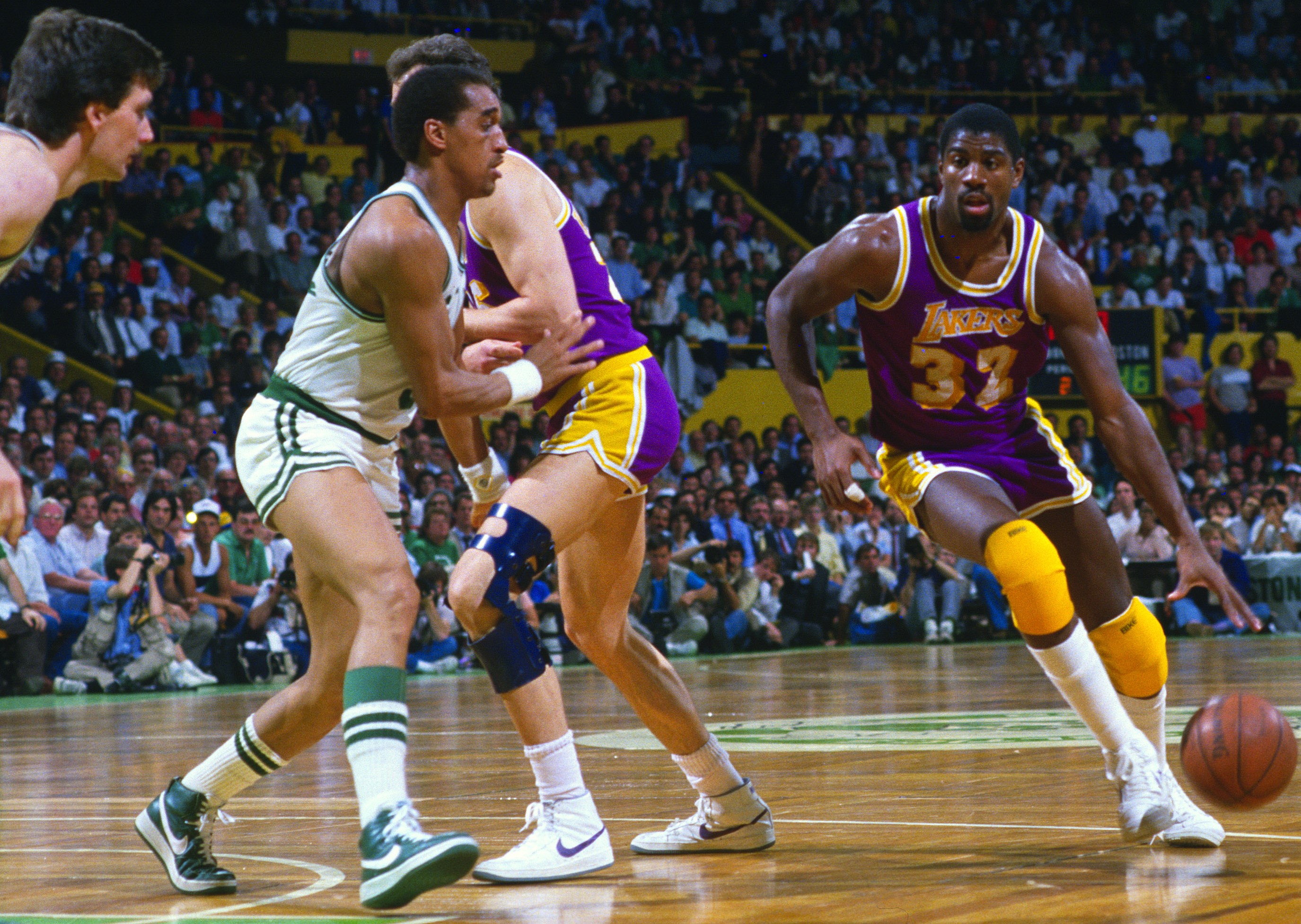 Magic Johnson of the Los Angeles Lakers looks to drive pass Dennis Johnson of the Boston Celtics.