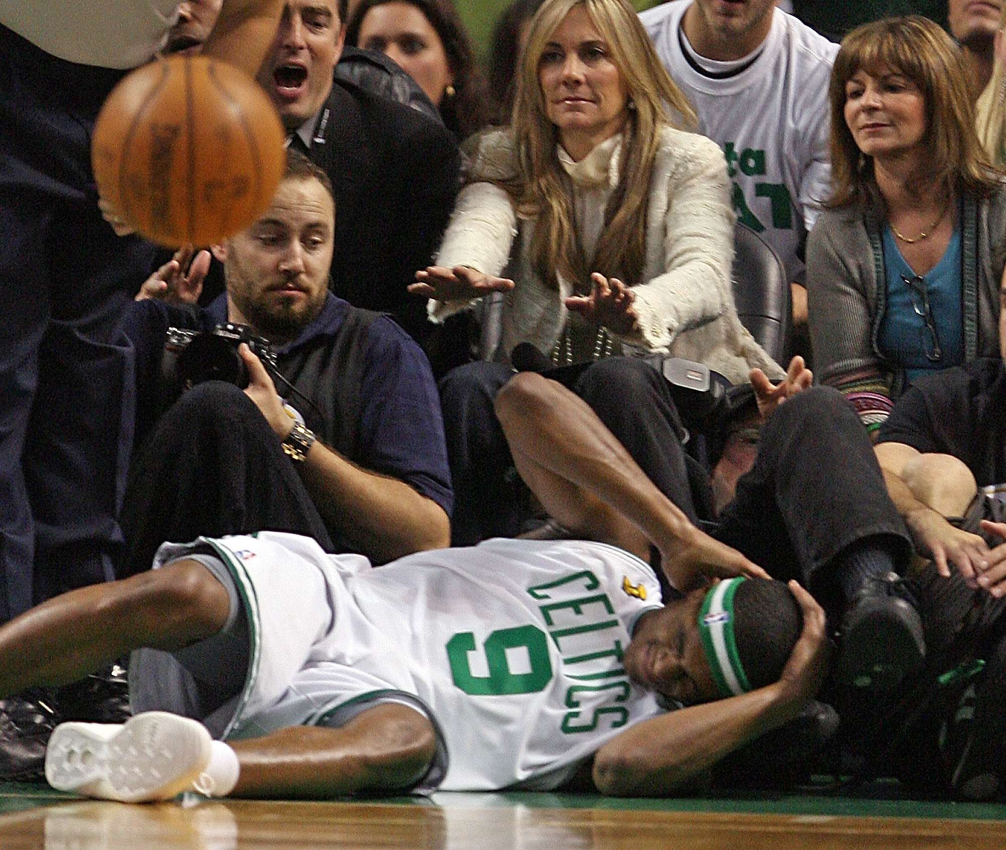 Boston Celtics guard Rajon Rondo holds his head after falling into the stands.
