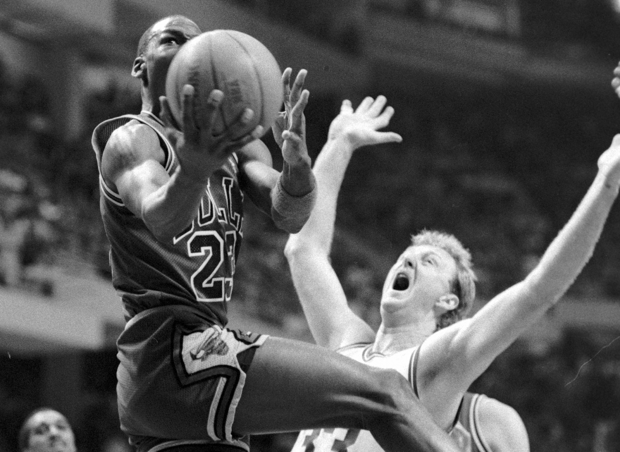 Chicago Bulls guard Michael Jordan (left) crashes into Boston Celtics forward Larry Bird as he goes up for two points.