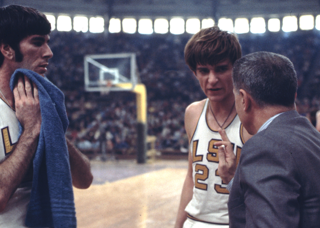 Pete Maravich of the LSU Tigers takes instruction from head coach and father, Press Maravich.