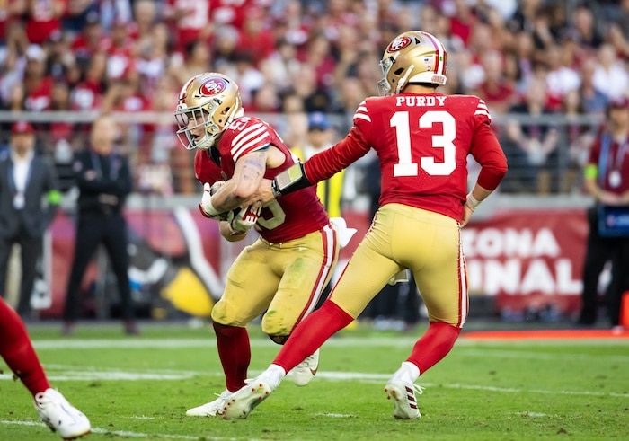Brock Purdy hands the ball to Christian McCaffrey.