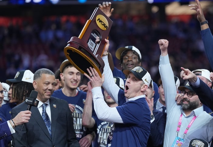 Connecticut Huskies head coach Dan Hurley hoists the championship trophy