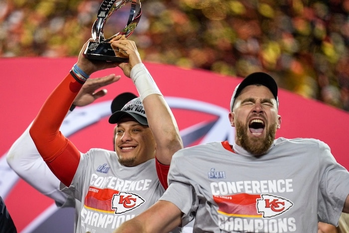 Kansas City Chiefs quarterback Patrick Mahomes (15) raises the Lamar Hunt Trophy with tight end Travis Kelce (87.