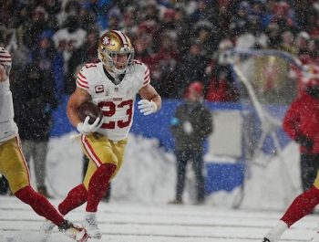 49ers Christian McCaffrey carries the ball for several yards.