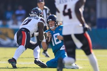 Jacksonville Jaguars quarterback Trevor Lawrence (16) slides for a down as Houston Texans linebacker Azeez Al-Shaair.
