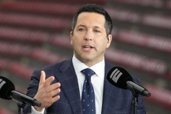 Adam Schefter sits in front of a mic.