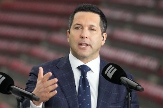 Adam Schefter sits in front of a mic.