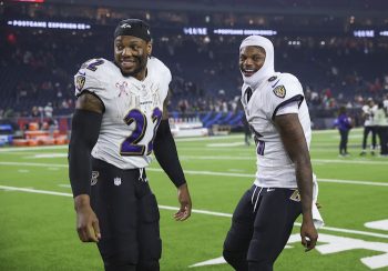 Baltimore Ravens running back Derrick Henry and quarterback Lamar Jackson stand next to each other.