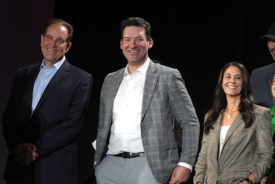 Jim Nantz, Tony Romo, and Tracy Wolfson stand in a line.