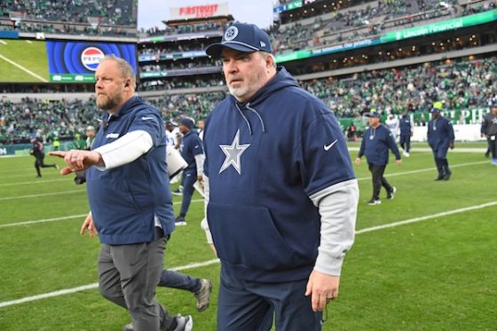 Mike McCarthy walks on the field.