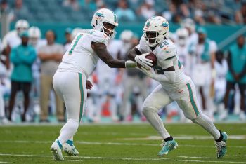 Miami Dolphins quarterback Tua Tagovailoa hands the ball off.