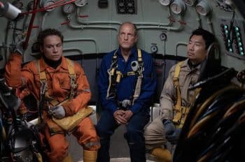 Three scuba divers sit in a pod and wait.