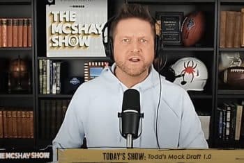 Todd McShay speaks in front of a mic.