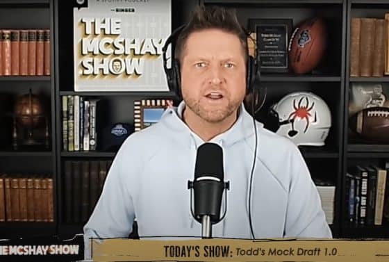 Todd McShay speaks in front of a mic.