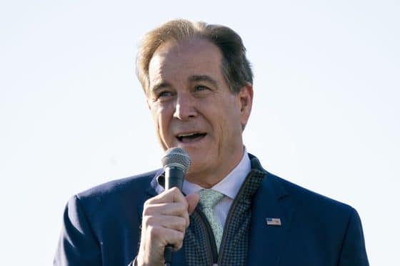 American sportscaster Jim Nantz holds a mic to his mouth.