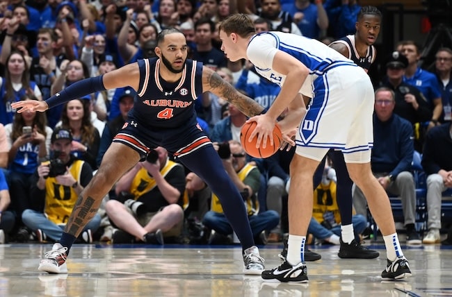 Cooper Flagg holds the ball in front of Johni Broome.