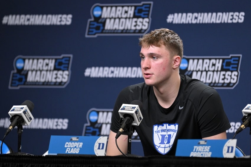 Cooper Flagg sits at the podium.