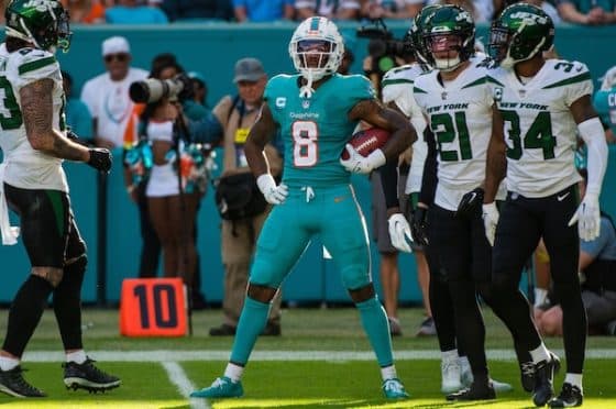 Jevon Holland holds the ball and stands.