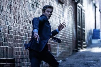 Jack Quaid runs with a gun.