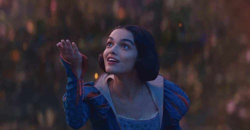 A princess holds an apple up.