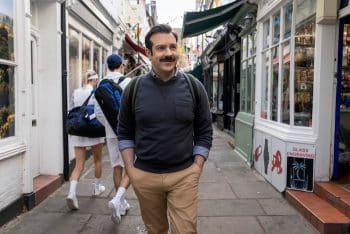 Jason Sudeikis walks down the street in Ted Lasso.