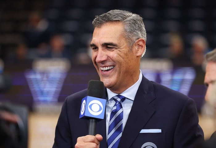 Jay Wright holds a mic up.