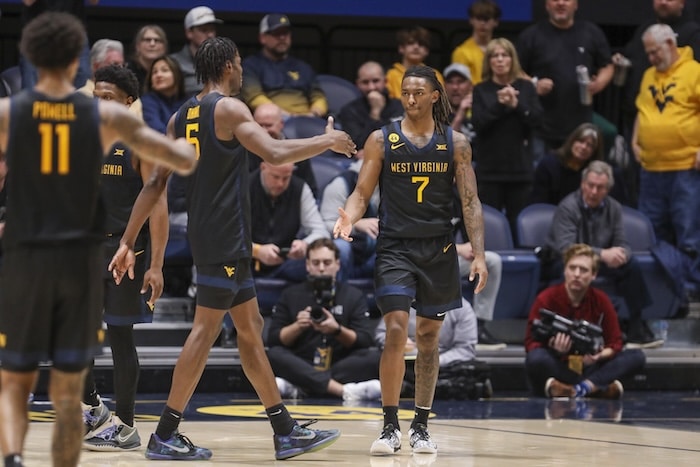 West Virginia basketball stands on court.
