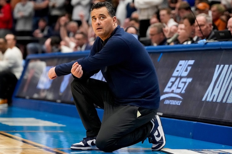 Sean Miller kneels on the sidelines.