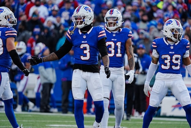 A group of Bills players run on the field.