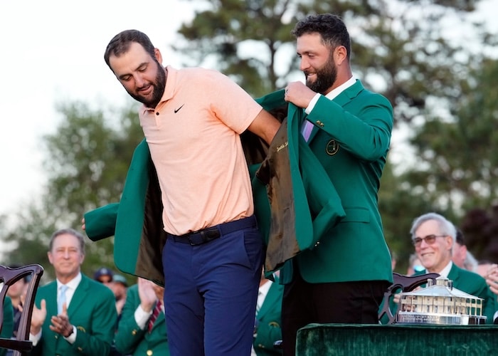 2023 Masters champion Jon Rahm places the green jacket on 2024 Masters champion Scottie Scheffler.