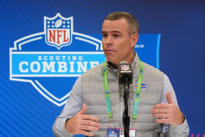 Buffalo Bills general manager Brandon Beane holds hand up at podium.
