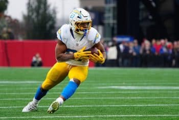 J.K. Dobbins holds and runs the ball for the Chargers.