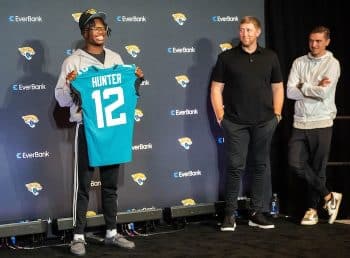 Travis Hunter holds up a jersey.