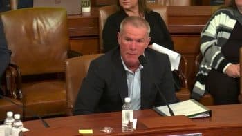 Brett Favre sits at a table and stares.