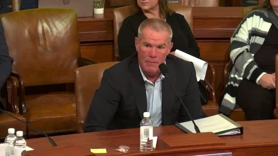 Brett Favre sits at a table and stares.