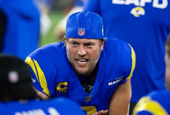 Los Angeles Rams quarterback Matthew Stafford sits on a knee.