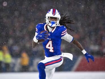 James Cook runs the ball in the snow.
