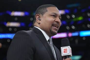 ESPN analyst Mark Jackson holds a mic.