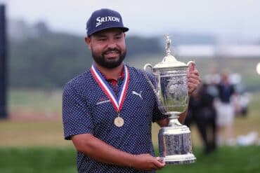 JJ Spaun holds a trophy.