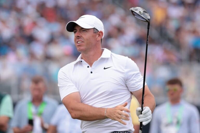 Rory McIlroy swings a club.