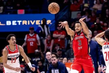 CJ McCollum throws the ball next to Jordan Poole.