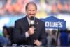 Bill Cowher holds a microphone up.