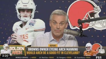 Colin Cowherd sits in front of a mic.