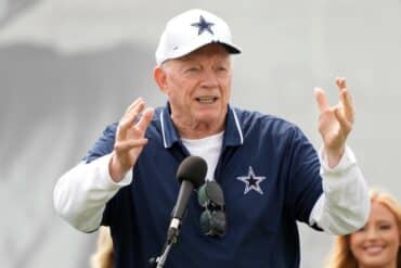 Dallas Cowboys owner Jerry Jones holds his hands up.