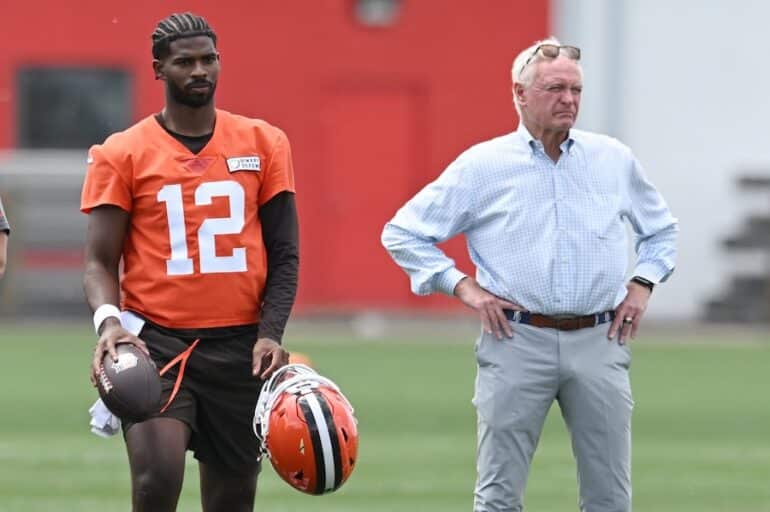 Jimmy Haslam and Shedeur Sanders stand on the field.