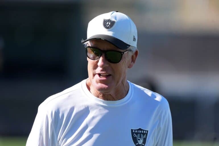 Pete Carroll stands on the field and stares.