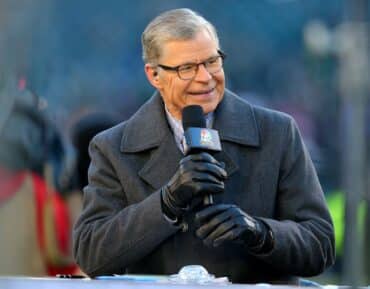 Dan Patrick holds a microphone.