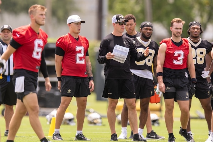 Saints quarterbacks stand in practice.