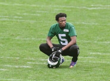 Garrett Wilson sits on the field.